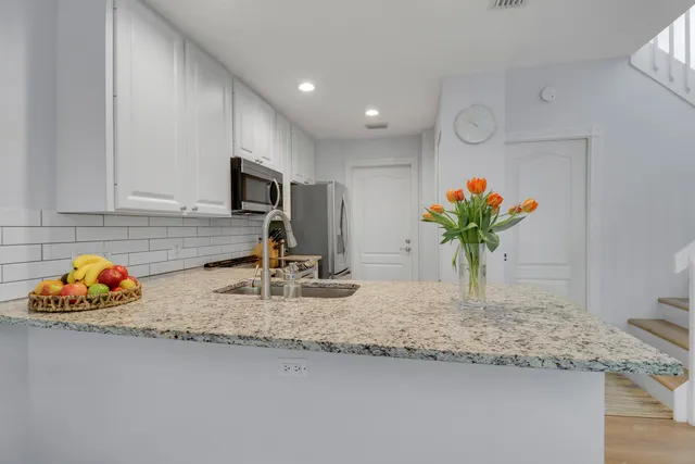 a kitchen with granite countertop kitchen island stainless steel appliances a sink and a counter top