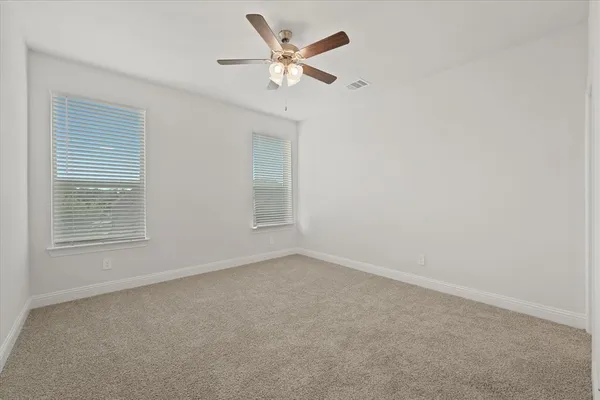 an empty room with a window and a ceiling fan