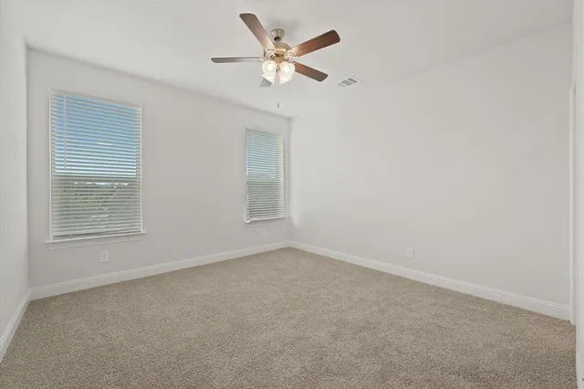 an empty room with a window and a ceiling fan