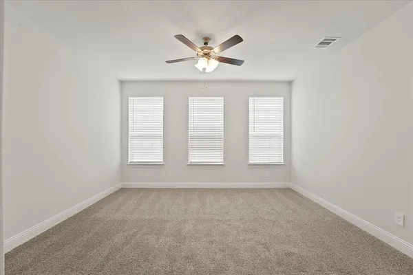 an empty room with window and ceiling fan