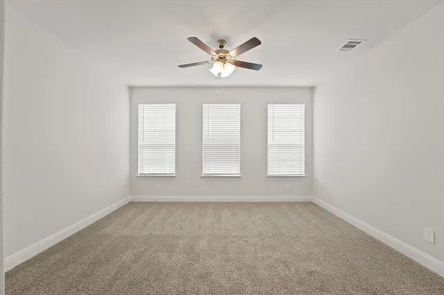 an empty room with window and ceiling fan