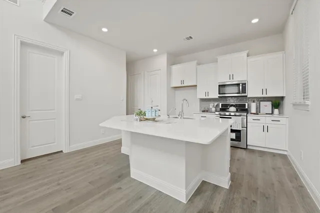 a kitchen with stainless steel appliances a sink stove and cabinets