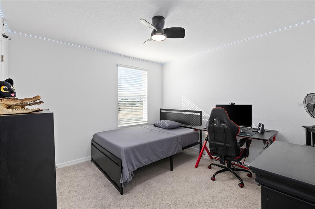 16507 Windmill Forge Pass Wimauma, FL 33598 - Photo 25 of 48 a bedroom with a bed and a desk
