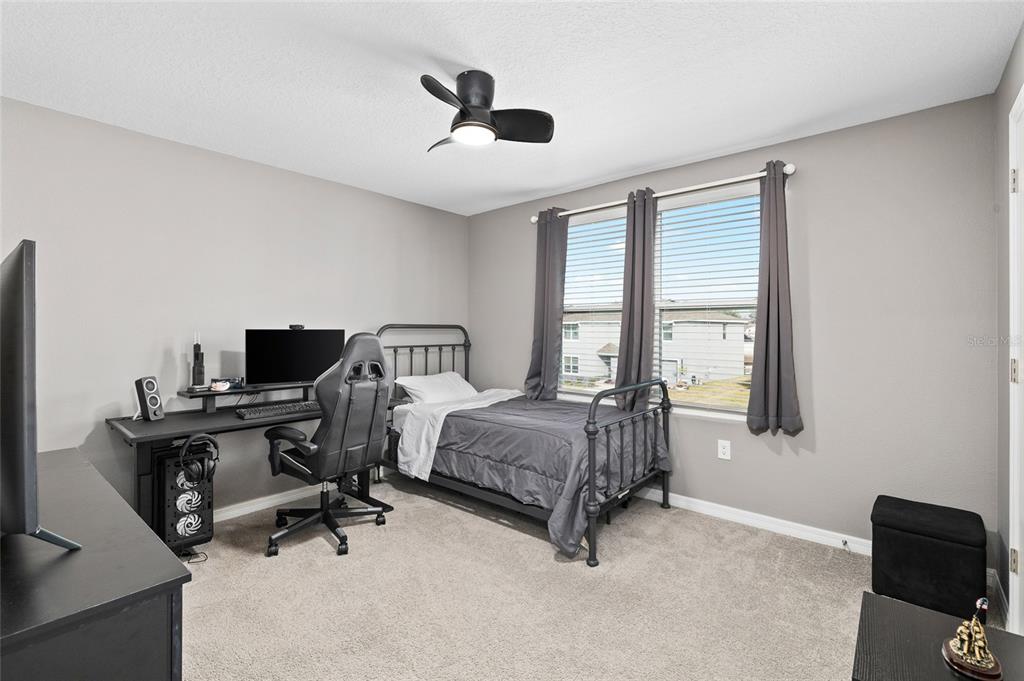 16507 Windmill Forge Pass Wimauma, FL 33598 - Photo 28 of 48 a bedroom with a bed and a chandelier
