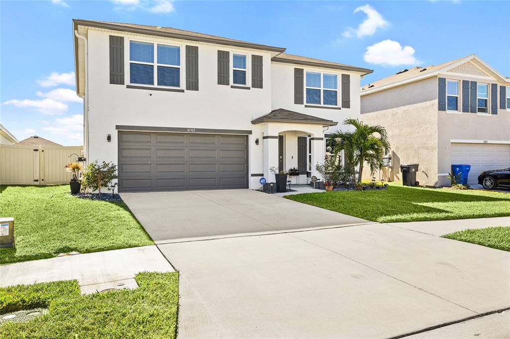 16507 Windmill Forge Pass Wimauma, FL 33598 - Photo 38 of 48 a front view of a house with a yard and potted plants