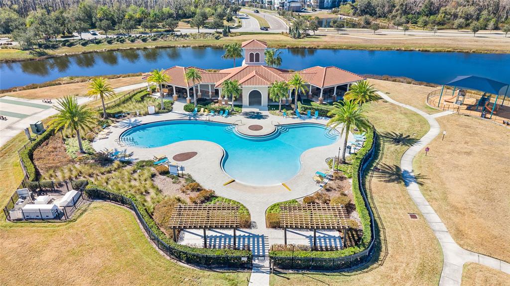 16507 Windmill Forge Pass Wimauma, FL 33598 - Photo 9 of 48 a view of a swimming pool with lawn chairs under an umbrella