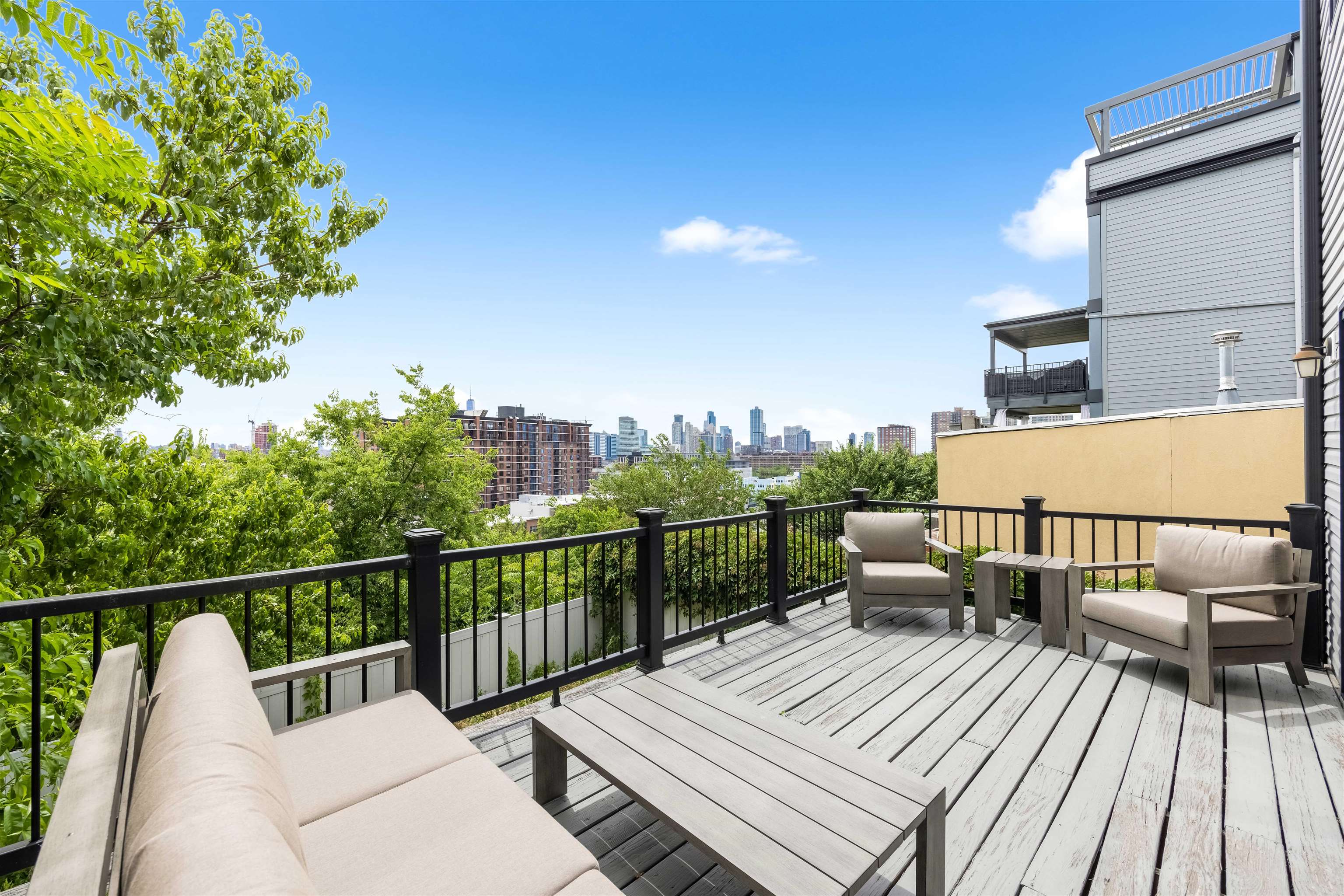 107 Mountain Road Jersey City, NJ 07307 - Photo 14 of 41 a view of a balcony with wooden floor chairs and iron fence