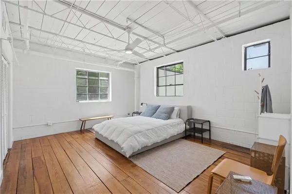 a bedroom with a bed and wooden floor