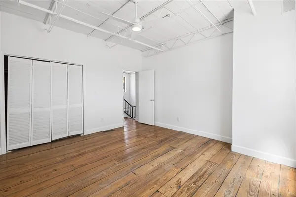 an empty room with wooden floor and windows