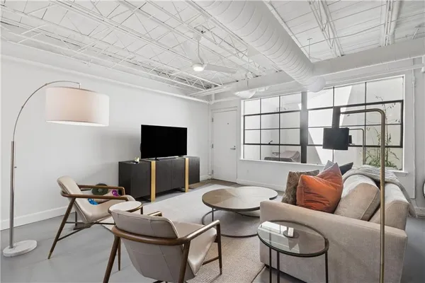 a living room with furniture a flat screen tv and a table