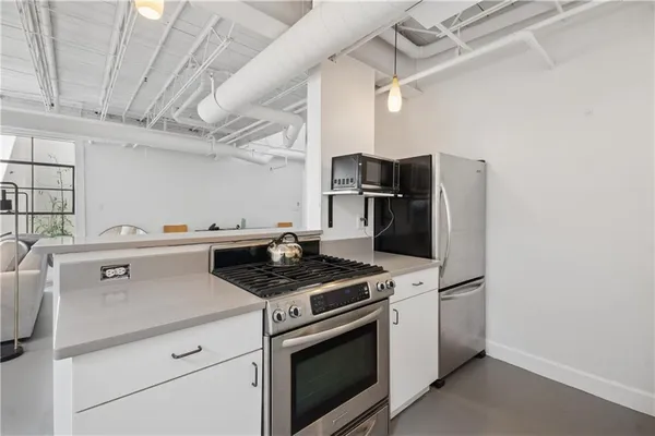 a kitchen with stainless steel appliances granite countertop a sink a stove and white cabinets