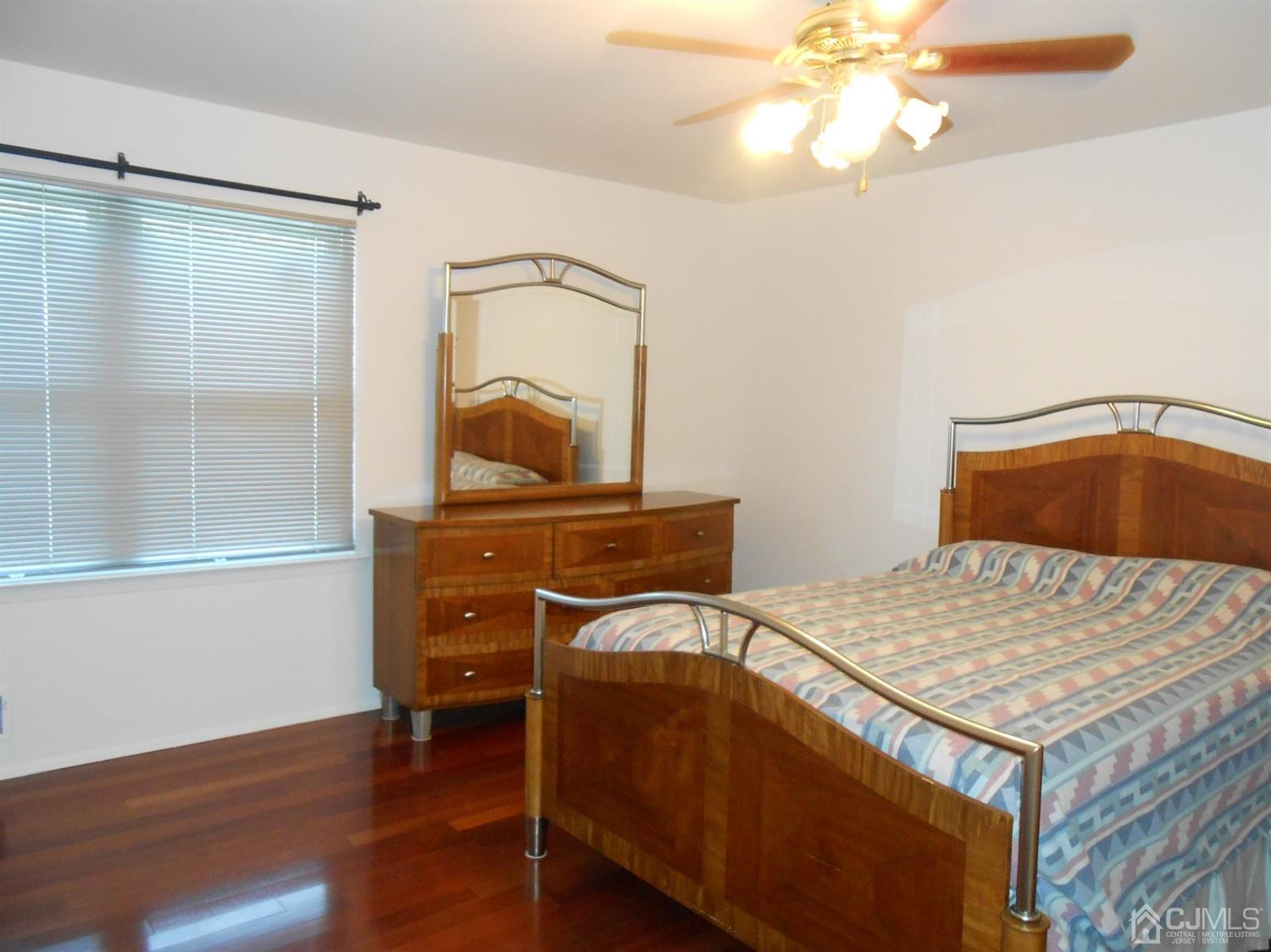 7206 Hana Road Edison, NJ 08817 - Photo 14 of 26 a bedroom with a bed and a dresser