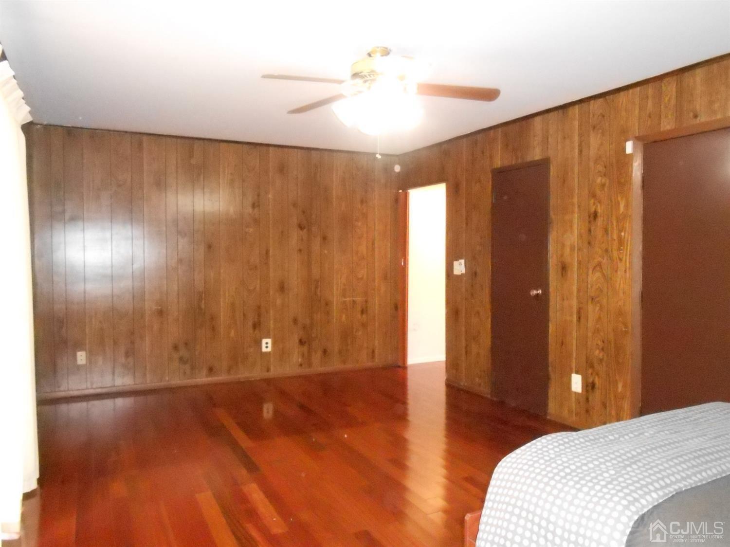 7206 Hana Road Edison, NJ 08817 - Photo 18 of 26 a bedroom with a bed and a chandelier fan