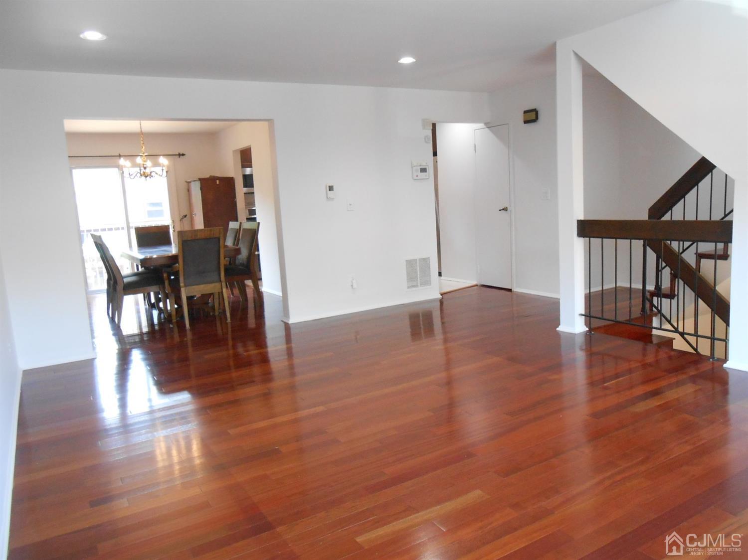 7206 Hana Road Edison, NJ 08817 - Photo 7 of 26 a view of a hallway with wooden floor table and chairs