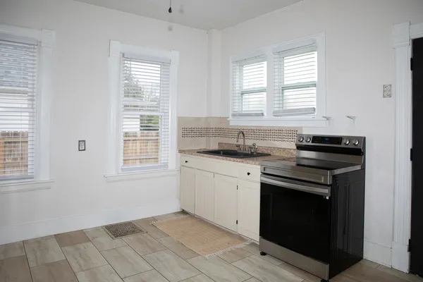 a kitchen with granite countertop a stove a sink and a window