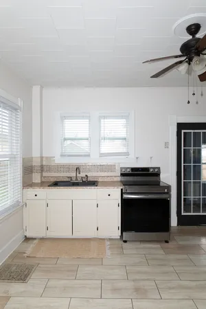 a kitchen with granite countertop a stove sink and cabinets