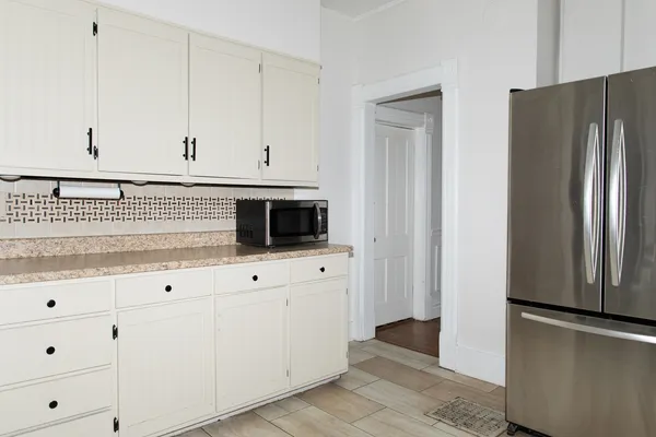 a kitchen with stainless steel appliances white cabinets and a refrigerator