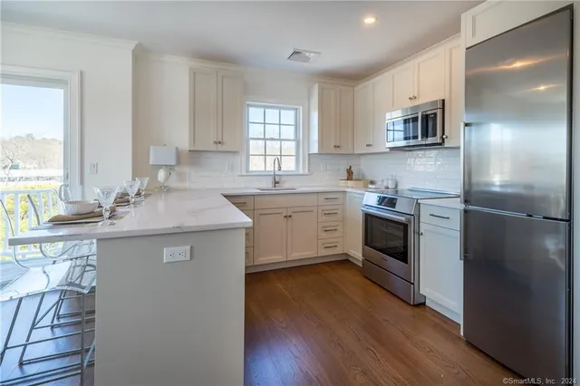 a kitchen with a sink cabinets appliances and a window