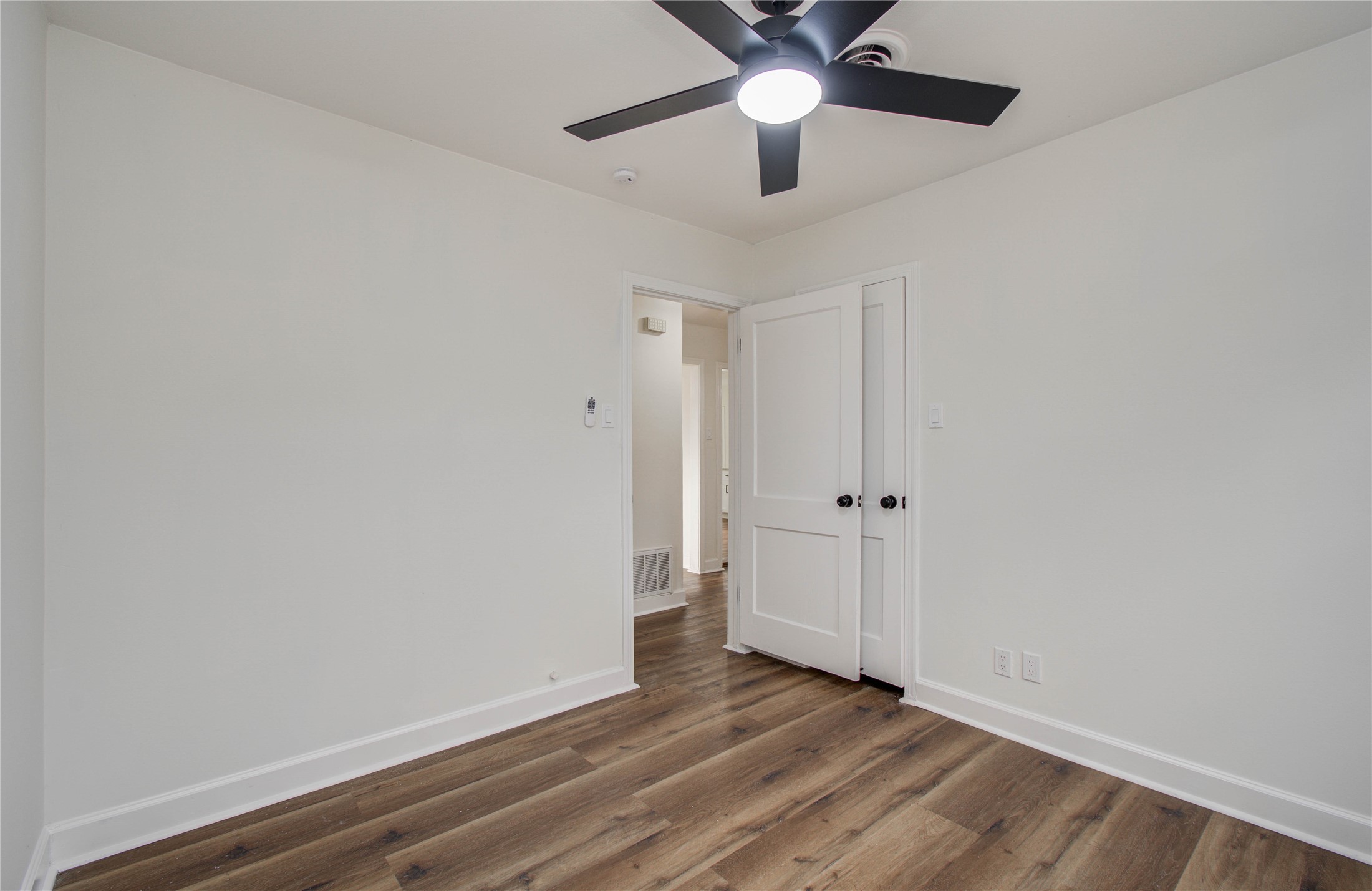 2417 Pecan Street Dickinson, TX 77539 - Photo 35 of 43 en empty room with wooden floor and ceiling fan