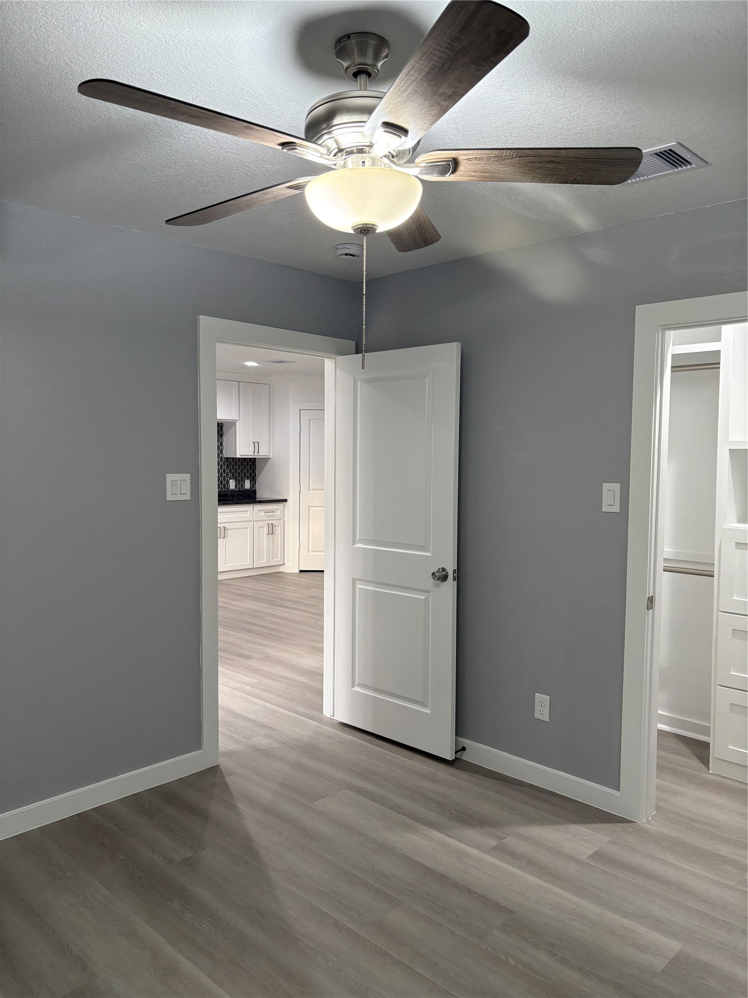 1809 Reese Street Houston, TX 77012 - Photo 20 of 23 a view of a livingroom with wooden floor a ceiling fan and kitchen space