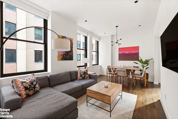 a living room with furniture a flat screen tv and kitchen view