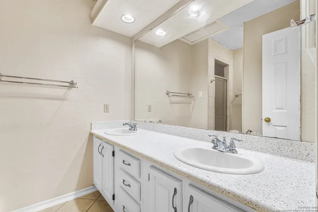 a bathroom with a granite countertop sink and a mirror