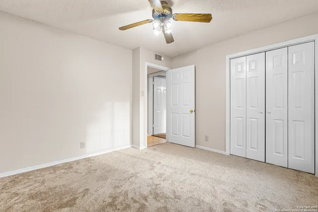 a view of empty room with ceiling fan
