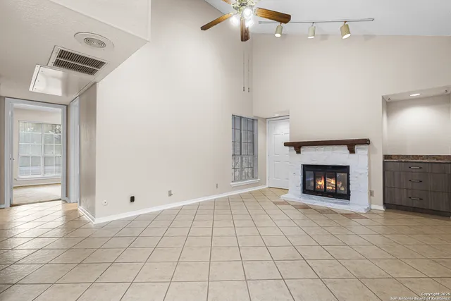 an empty room with windows and fireplace