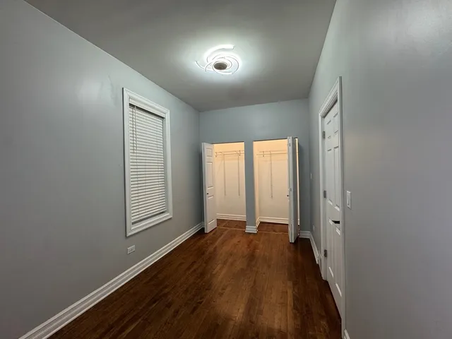 a view of hallway with windows and wooden floor