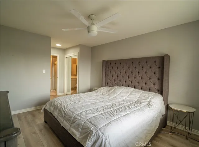 a bedroom with a bed and a flat tv screen on dresser