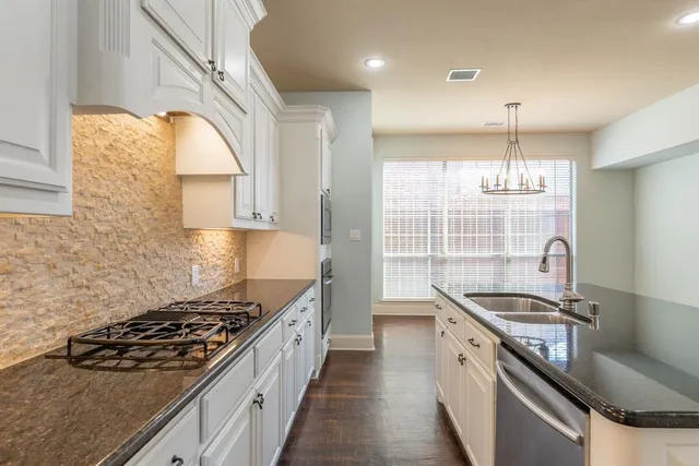 a kitchen with a stove a sink and a window