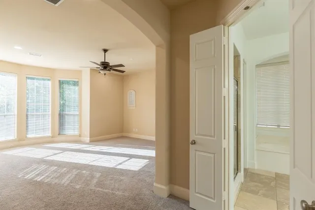 a view of a room with a ceiling fan and bathroom space