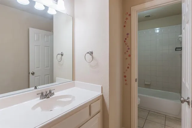 a bathroom with a granite countertop sink a mirror and a bathtub
