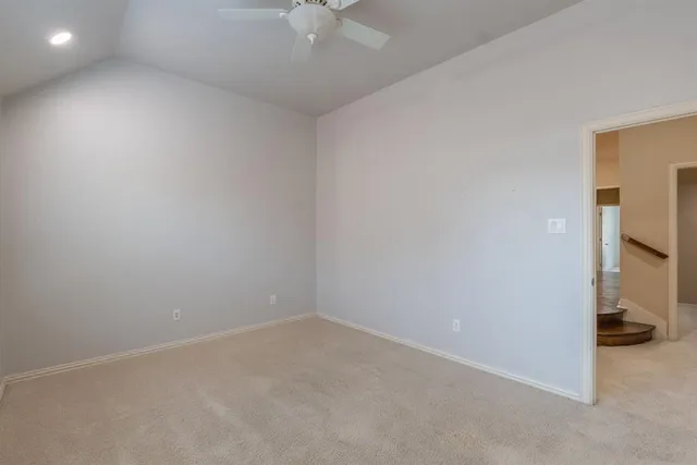 an empty room with a ceiling fan and bathroom