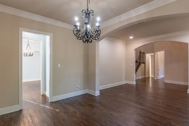 a view of a room with wooden floor chandelier and window