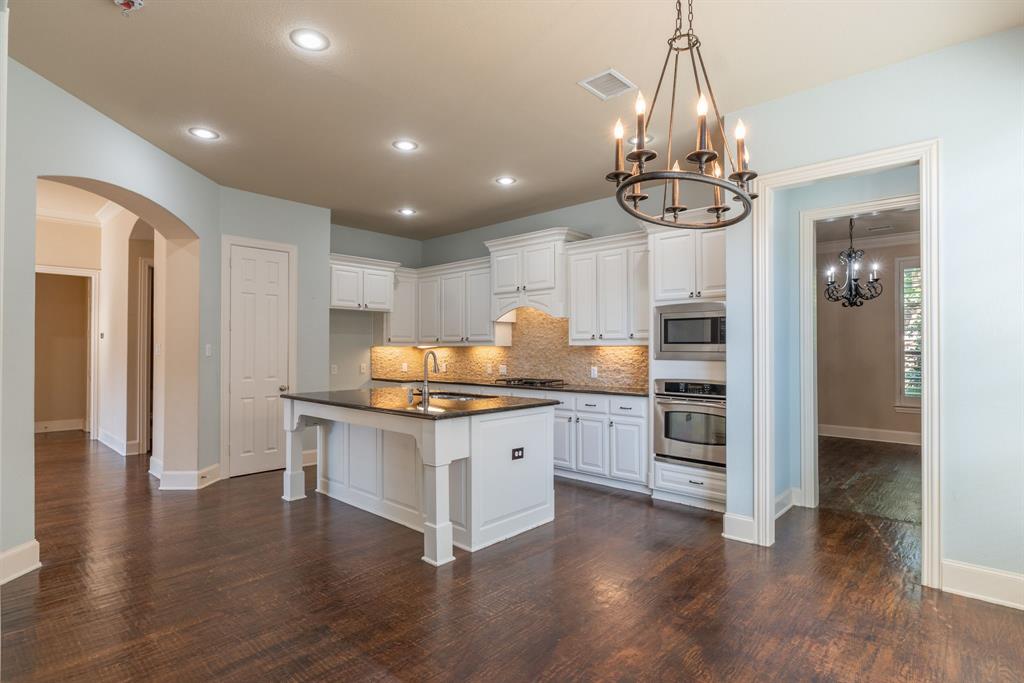 11775 Frontier Drive Frisco, TX 75033 - Photo 8 of 40 a kitchen with stainless steel appliances a stove refrigerator and cabinets