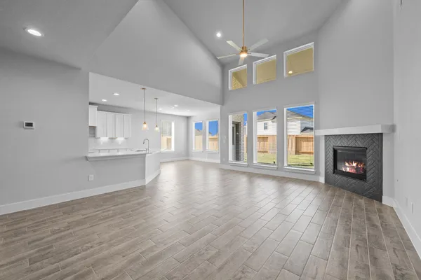 a view of an empty room with wooden floor fireplace and a window