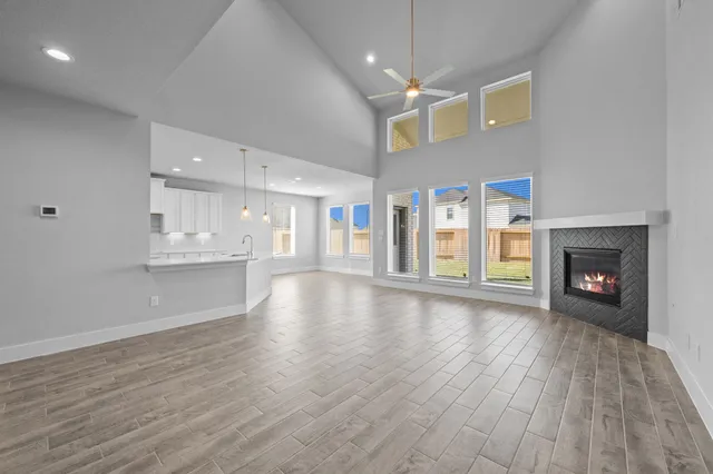 a view of an empty room with wooden floor fireplace and a window