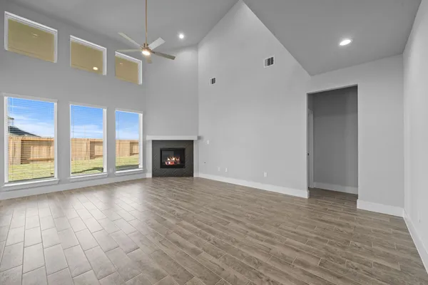 a view of an empty room with wooden floor and closet