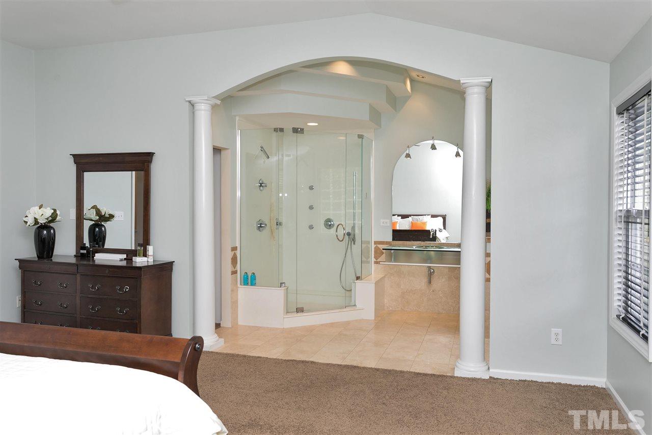 7314 Doverton Court Raleigh, NC 27615 - Photo 16 of 30 a bedroom with a bed and a view of bathroom