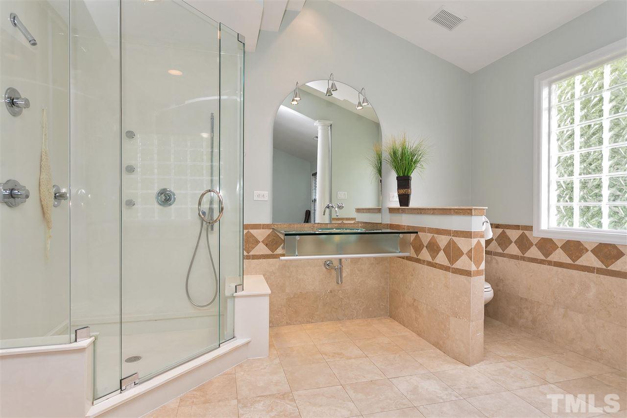 7314 Doverton Court Raleigh, NC 27615 - Photo 19 of 30 a bathroom with a tub a sink and a mirror