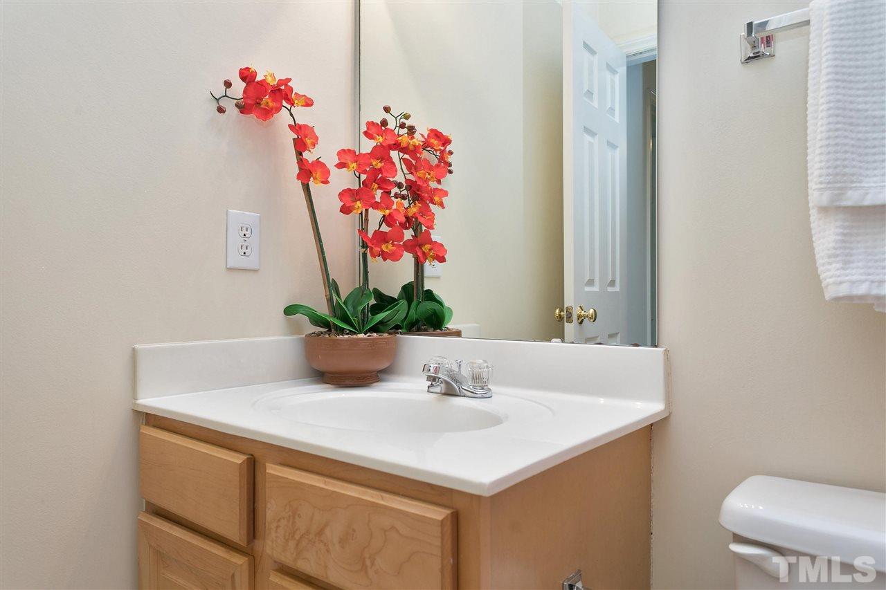 7314 Doverton Court Raleigh, NC 27615 - Photo 22 of 30 a bathroom with a sink a toilet and a mirror