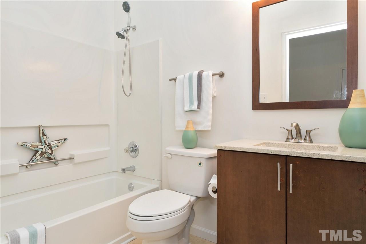 7314 Doverton Court Raleigh, NC 27615 - Photo 26 of 30 a bathroom with a granite countertop sink toilet and shower