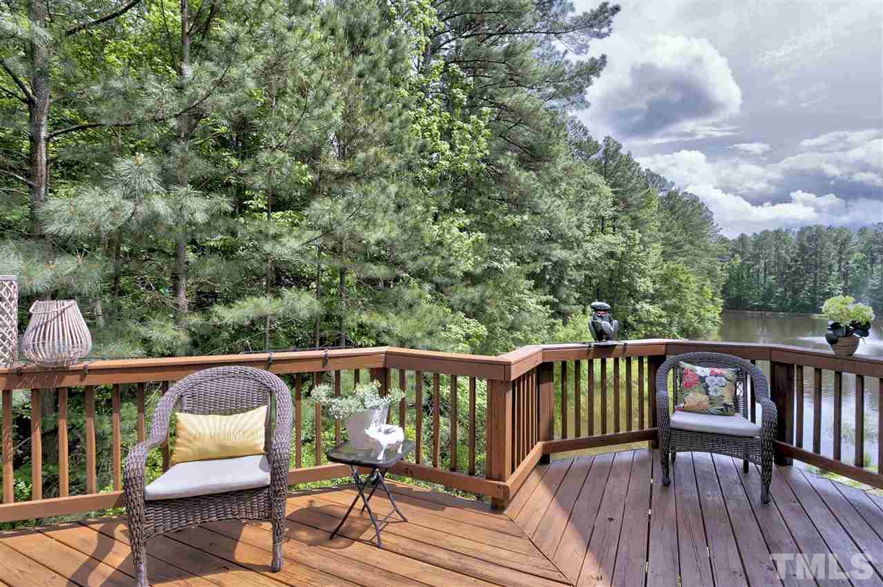 7314 Doverton Court Raleigh, NC 27615 - Photo 28 of 30 a view of a roof deck with table and chairs a barbeque with wooden floor and fence