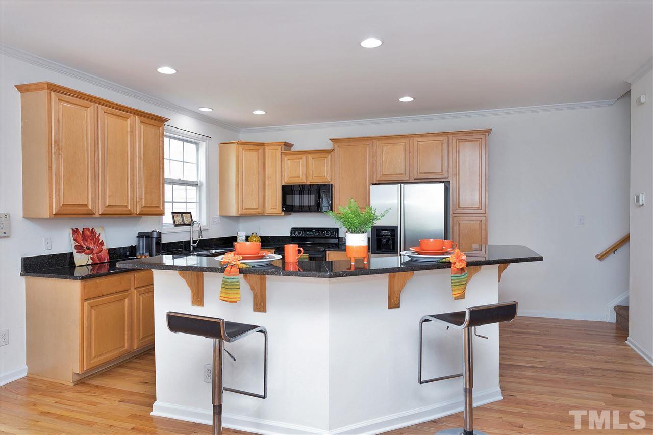 7314 Doverton Court Raleigh, NC 27615 - Photo 9 of 30 a kitchen with a sink a window and chairs