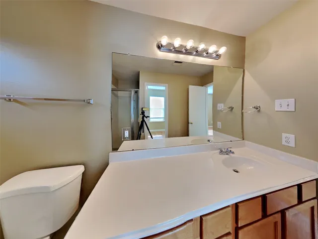 a en suite bathroom with a sink a large mirror and toilet