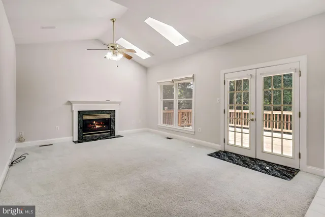 a view of an empty room with a fireplace and a window
