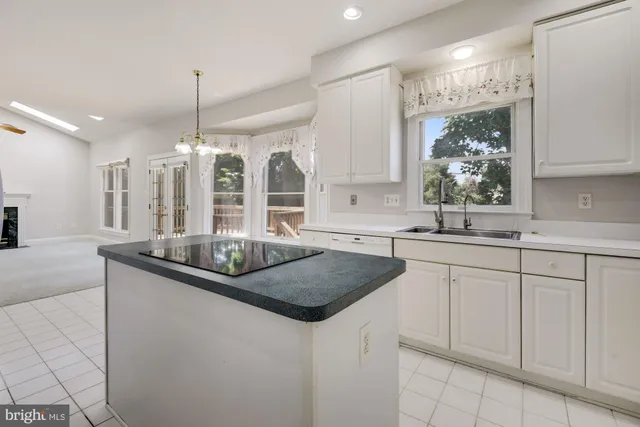 a kitchen with granite countertop a sink and white cabinets