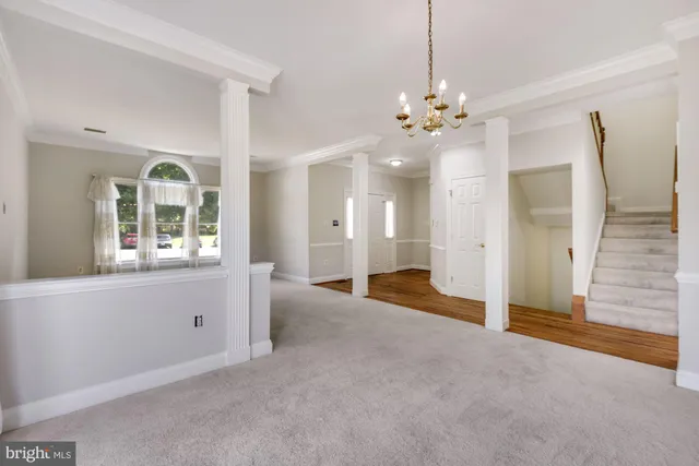 a view of a livingroom with a chandelier fan and windows