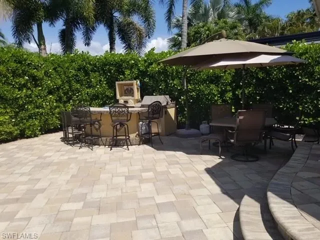 a view of a patio with table and chairs under an umbrella